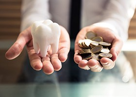 person holding tooth and coins
