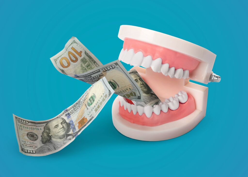 Fake teeth chomping 2 $100 bills with blue background